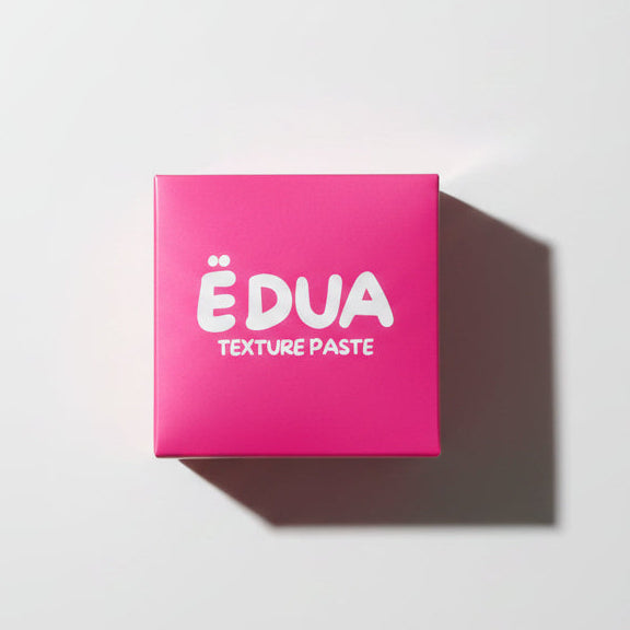 Pink container of ÉDUA Texture Paste on a white background